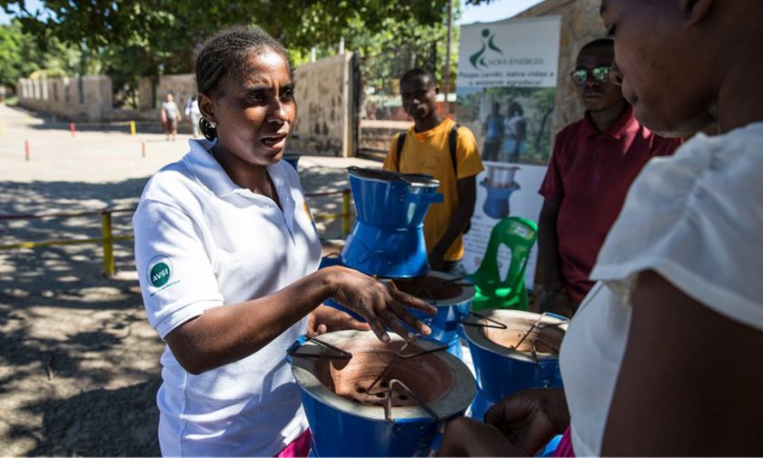 Donna  africana consegna sistema di cottura  alla comunità