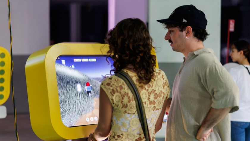 A man and a woman playing in front of a monitor