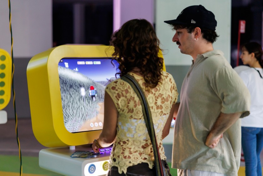 A man and a woman playing in front of a monitor