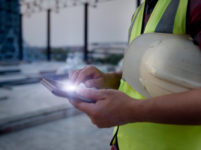 Detail of a worker's hands typing on a tablet