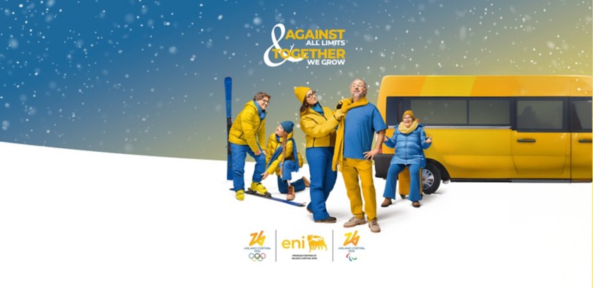 Gruppo di persone in abbigliamento invernale giallo e blu sulla neve, accanto a un furgone giallo, con slogan “Against all limits, together we grow”.