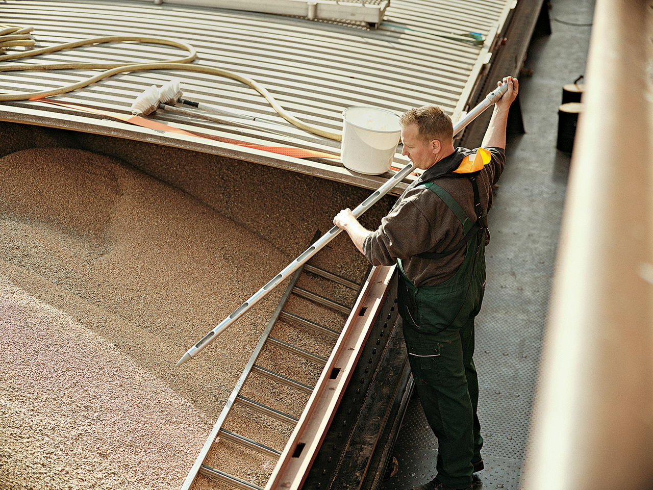 Ein Mischfuttermüller ­entnimmt auf dem Frachtschiff Proben des angelieferten ­Weizens und füllt sie in Beutel ab.