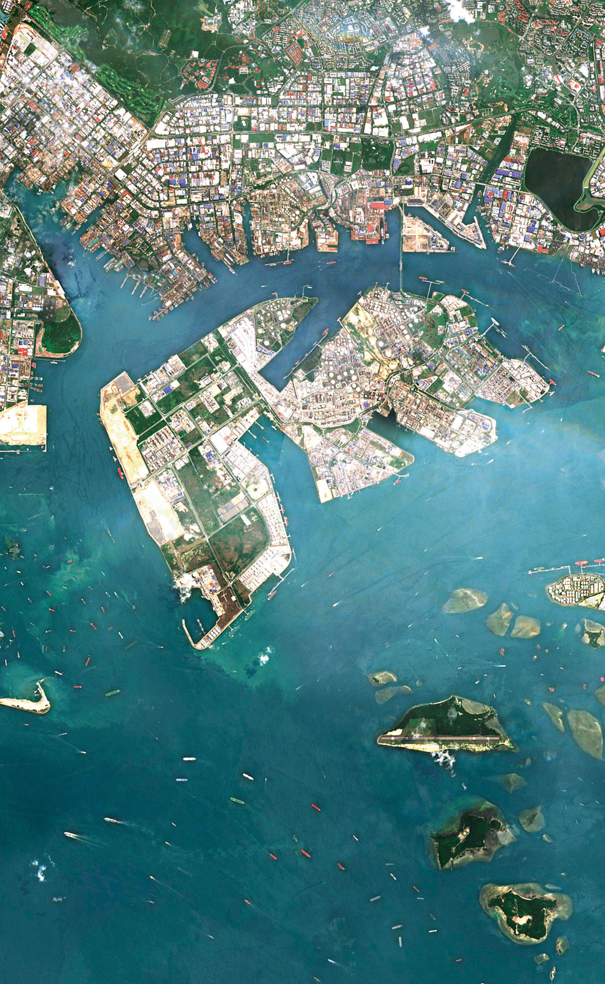 Beginnend in den 1990er-Jahren wurden sieben Inseln, die der Hauptinsel Singapurs vorgelagert sind, durch Landgewinnung zu Jurong Island (Bildmitte) vereinigt. Zahlreiche petrochemische Unternehmen haben sich hier angesiedelt, darunter auch Evonik.