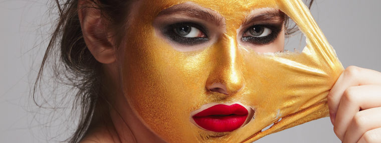 Beautiful woman with skin care product on her face