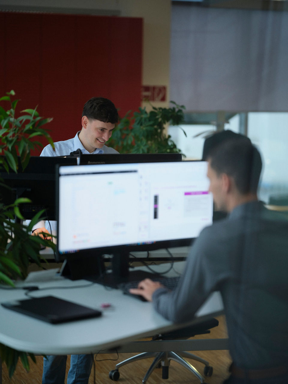 Johannes Dürholt and Thomas Asche are sitting across from each other at a shared workstation.