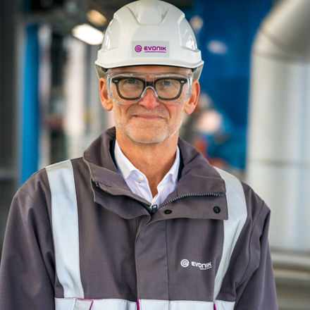Dr. Ralf Düssel mit Helm und Schutzbrille  in einer Arbeitsjacke.