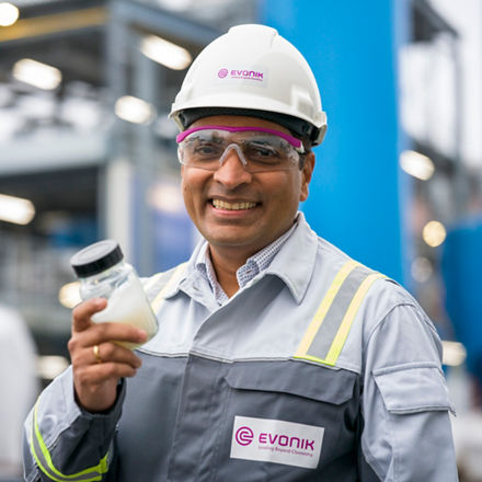 Sachin Wagh mit einer flüssigen Stoffprobe in einem Glasbehälter.