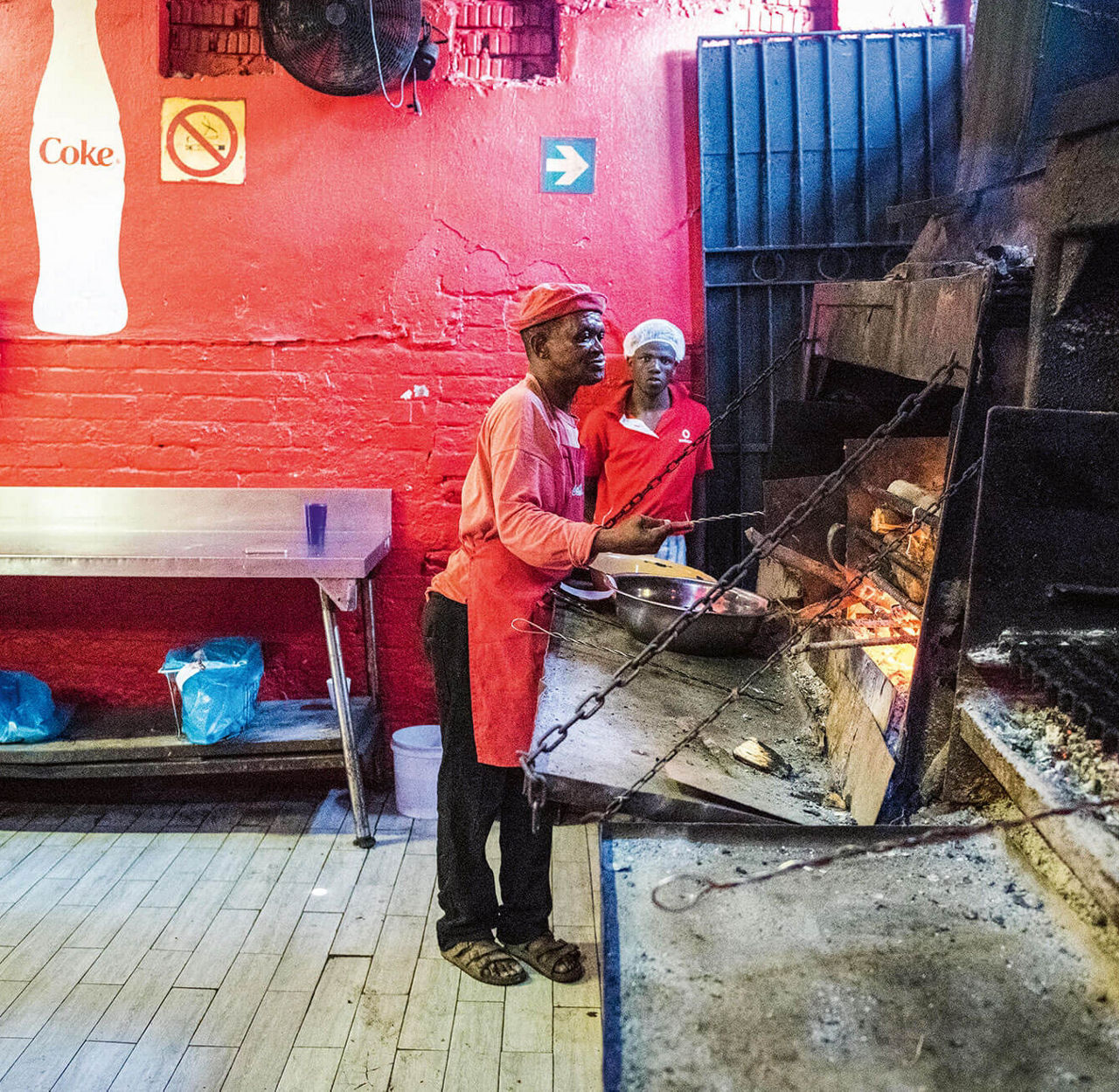 Two men in front of a large grill.