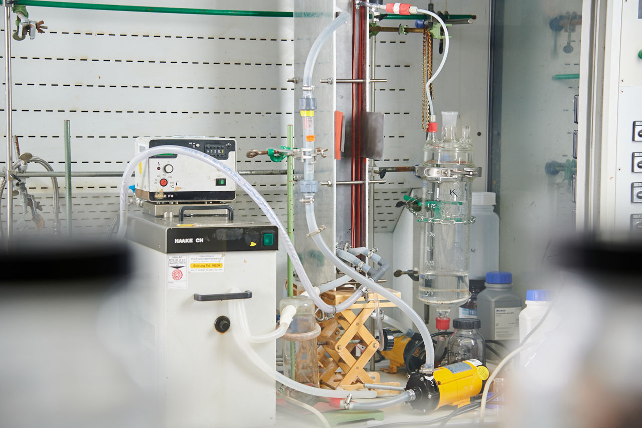 Two gray-and-white devices with hoses attached that terminate in a glass container.