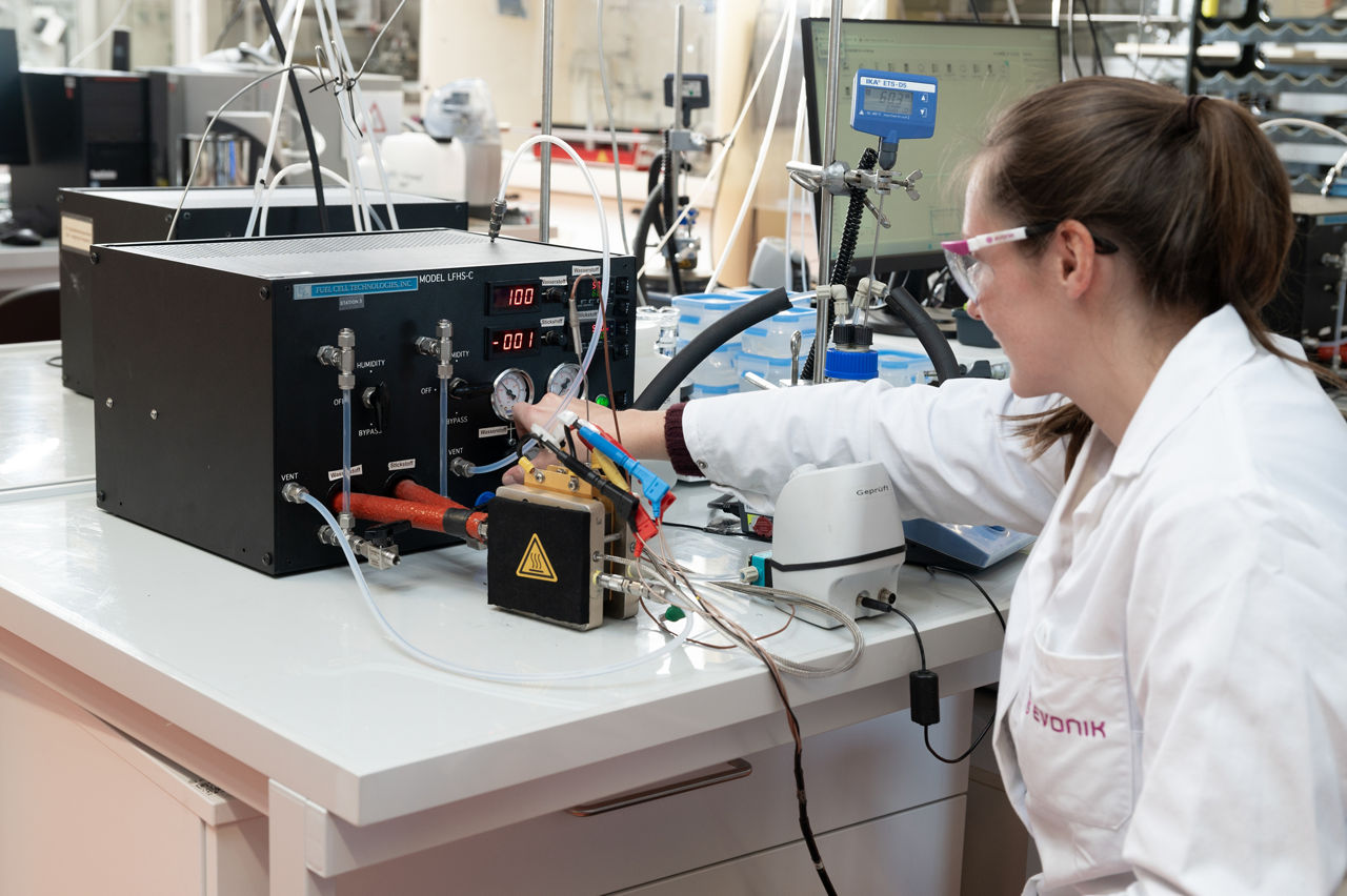Chemielaborantin Julia Writsch an einem Labortisch, Vor sich ein schwarzes Messgerät.