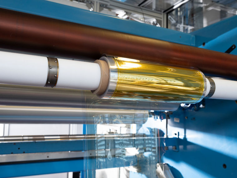 Eine goldglänzende Rolle auf einer weißen Produktionsachse.