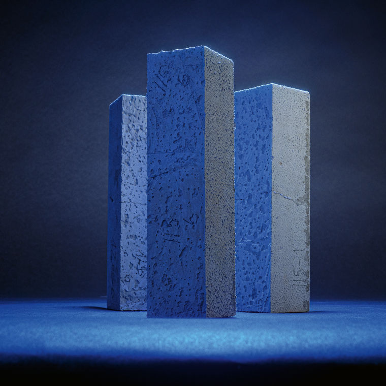 Three concrete test pieces, illuminated in blue like steles.