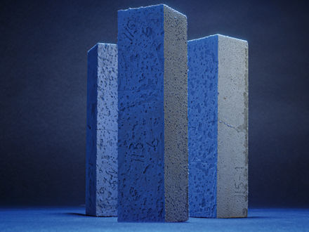 Three concrete test pieces, illuminated in blue like steles.