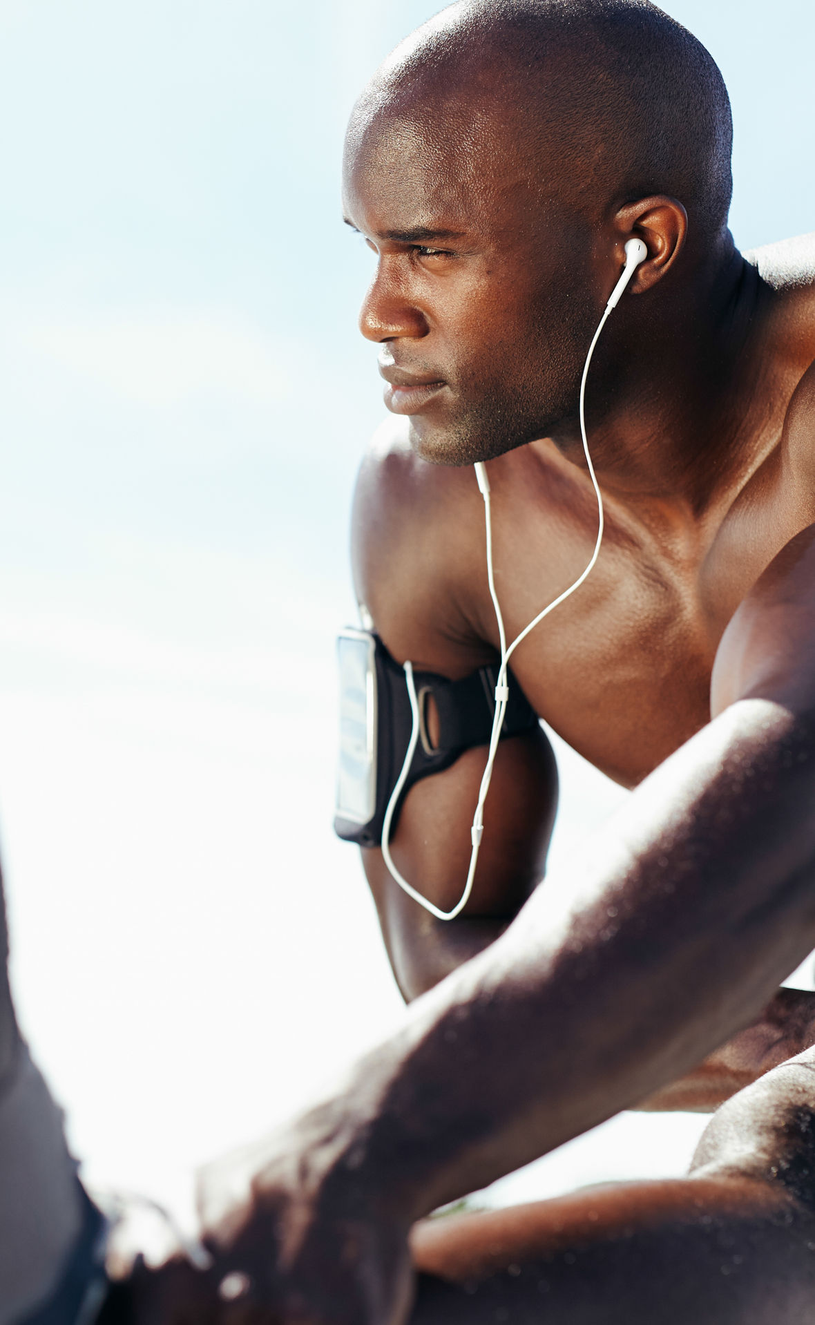 Muscular young man working out against sky.