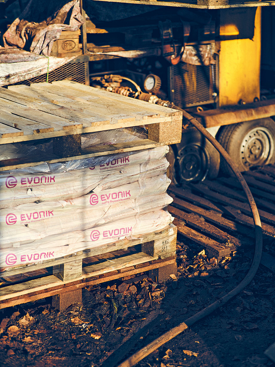 A wooden pallet with several bags labeled "Evonik."