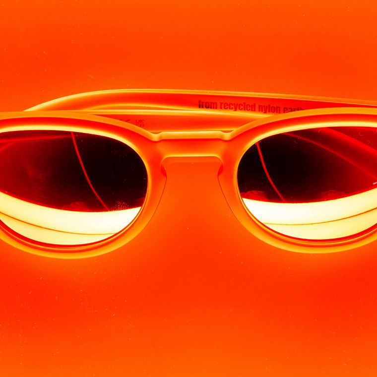 Eine Sonnenbrille vor orangefarbenem Hintergrund