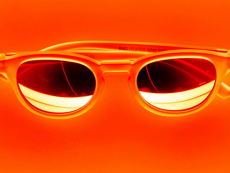 A pair of sunglasses against an orange background