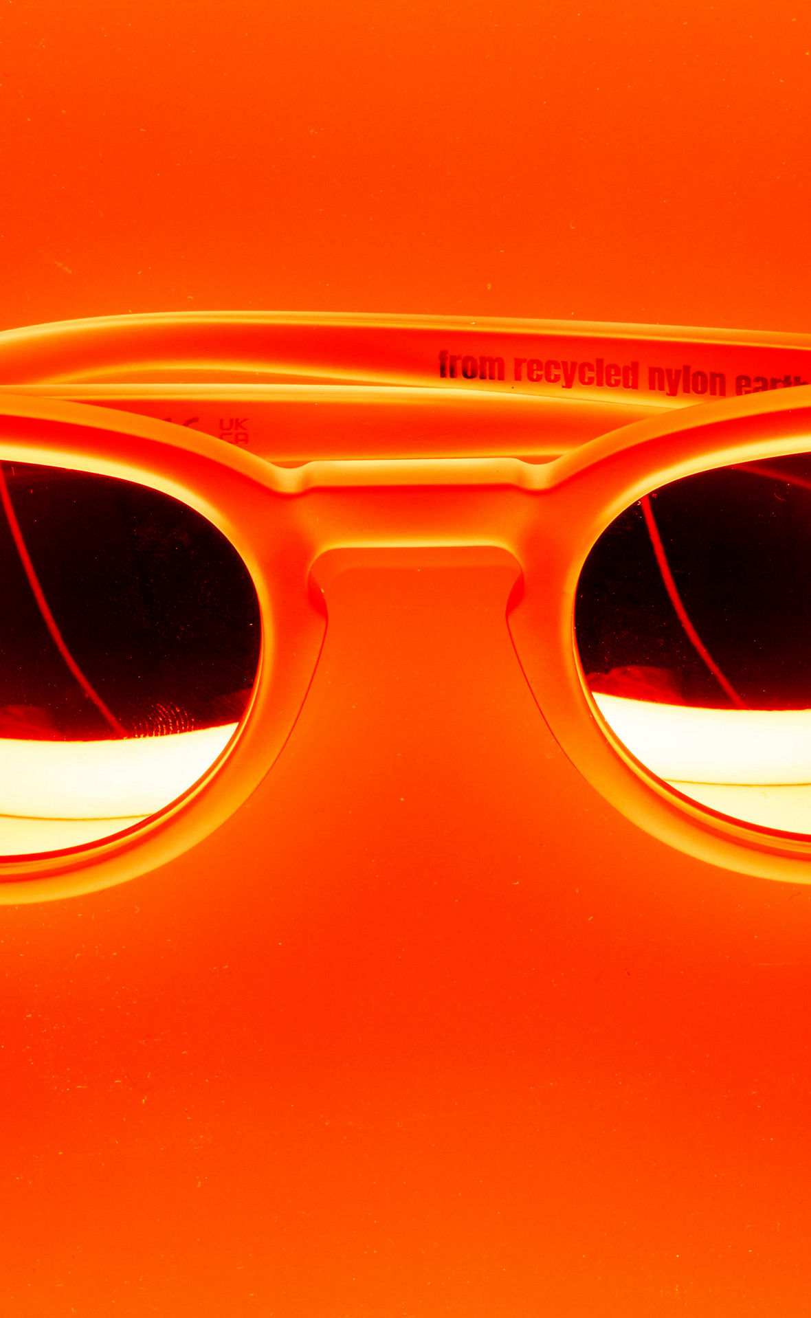 Eine Sonnenbrille vor orangefarbenem Hintergrund