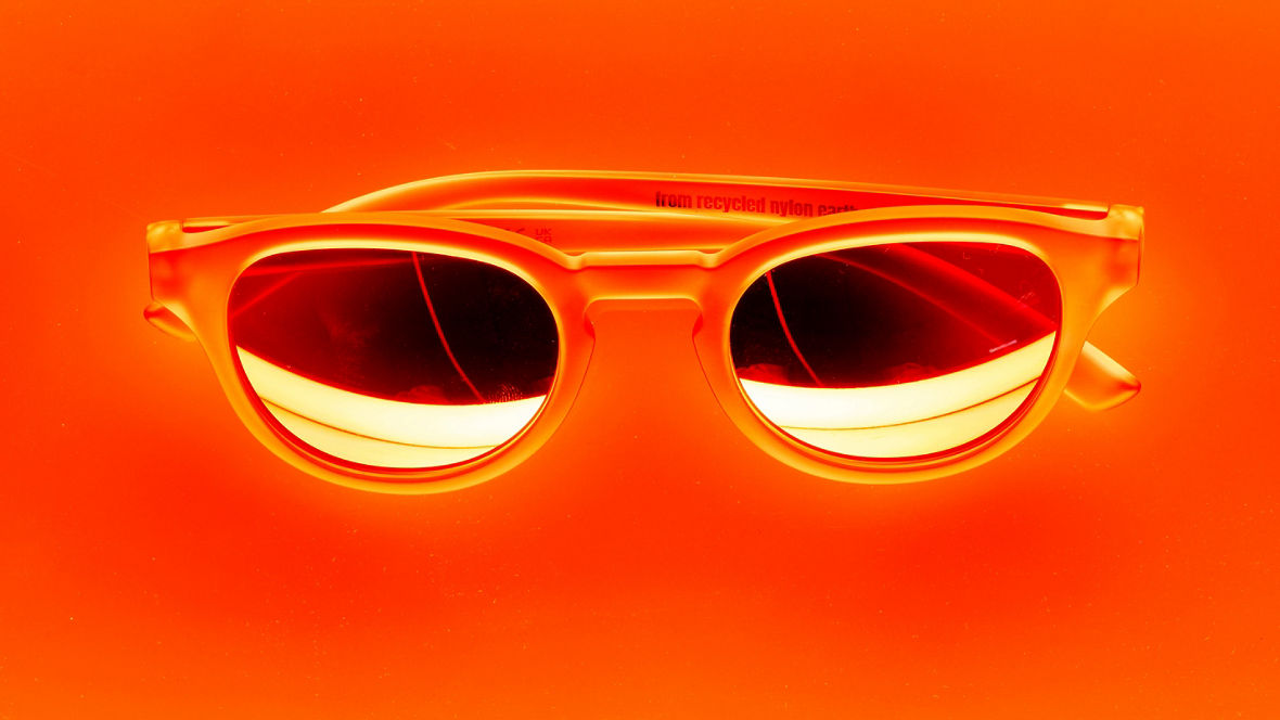 A pair of sunglasses against an orange background
