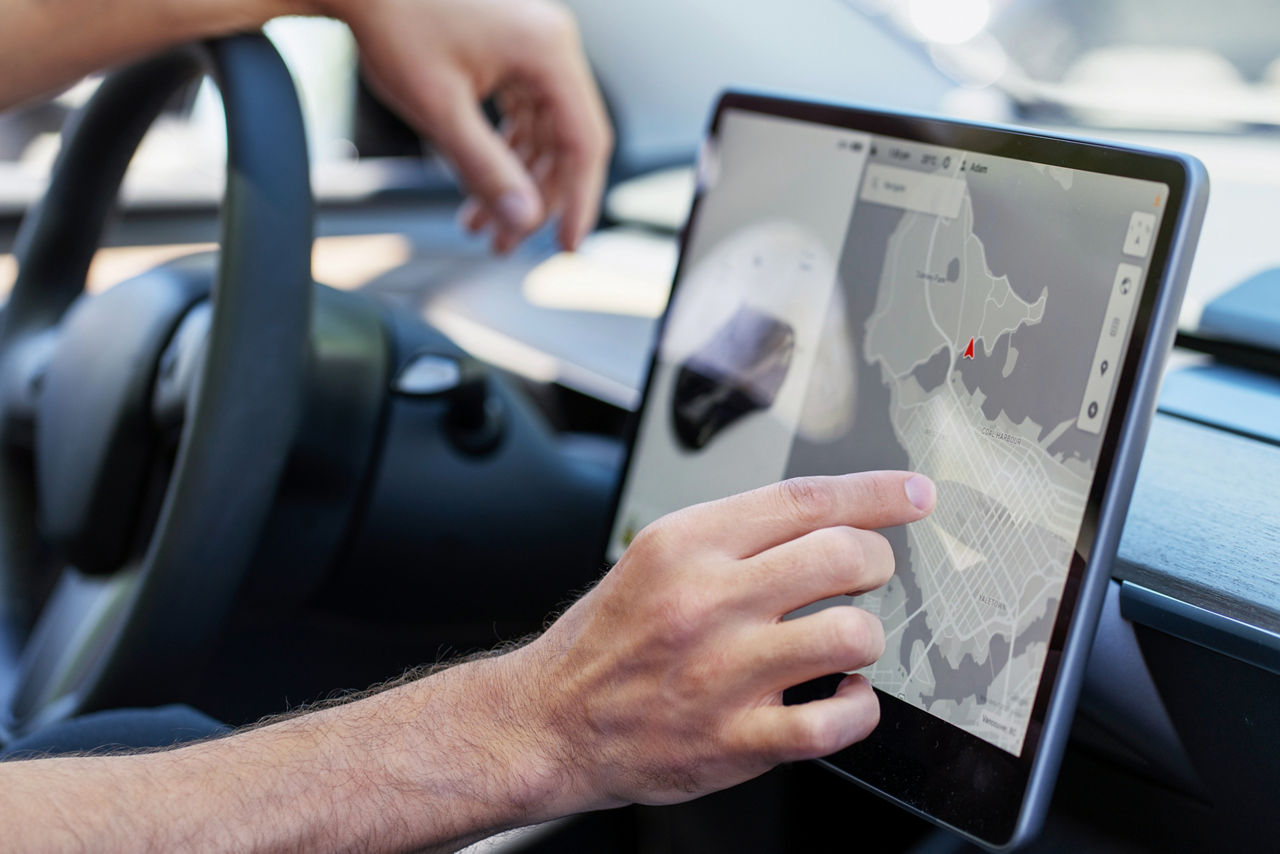 Man using car navigation system on large screen for efficient driving experience. Smart vehicle with advanced technology for seamless city navigation