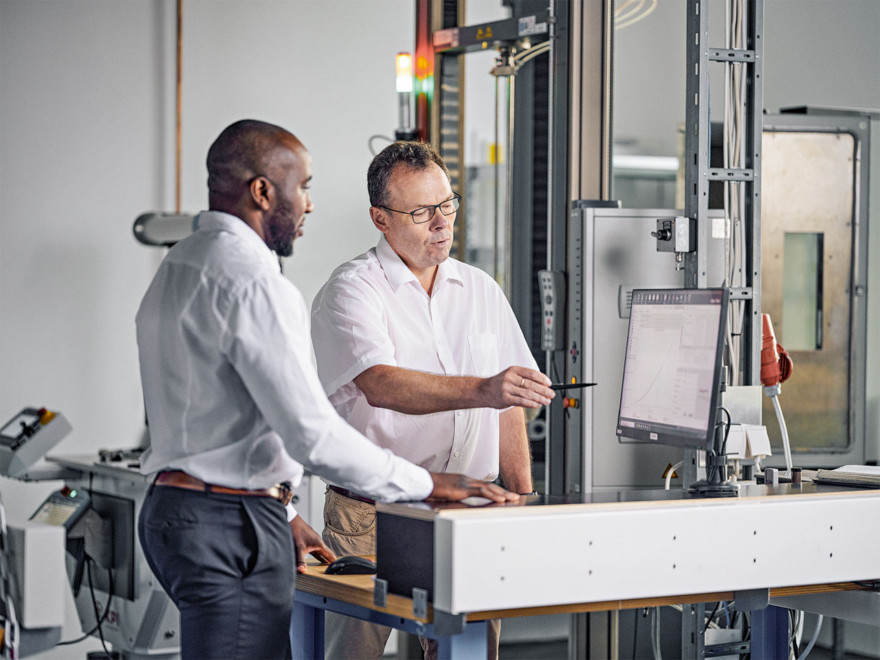 Christian Mani und Jens Kiesewetter besprechen sich vor einem Monitor.