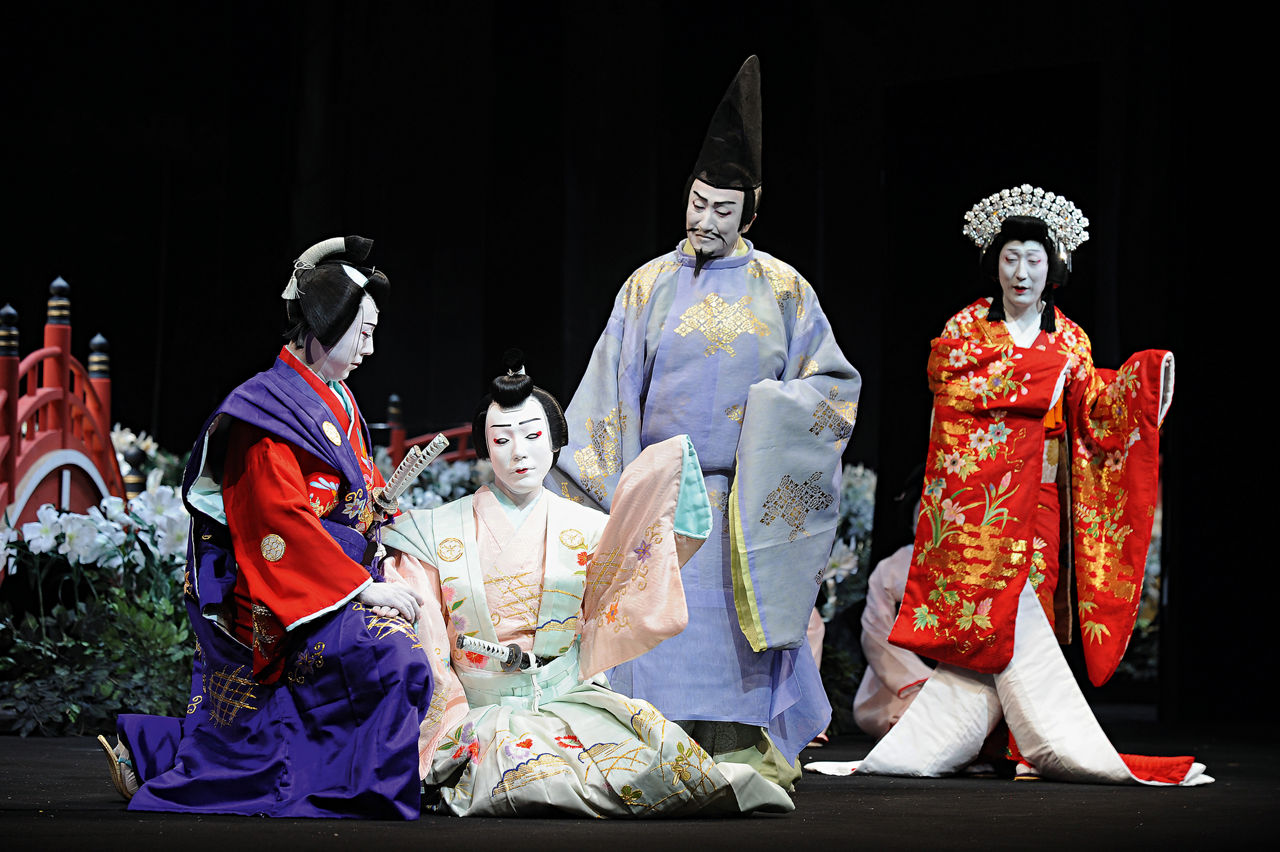 Actors with their faces painted white.