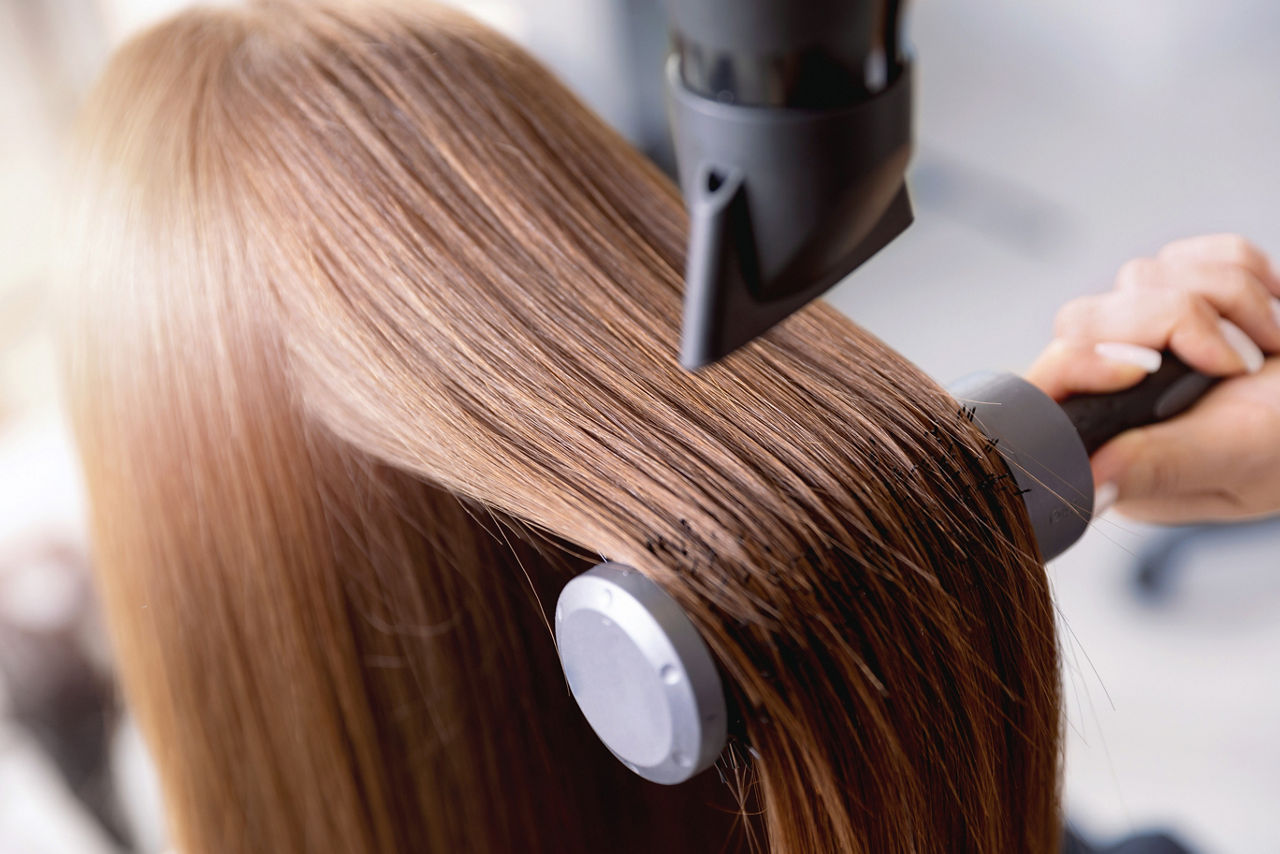 Professional haircare straightening in salon, Closeup of hair dryer, female stylist.