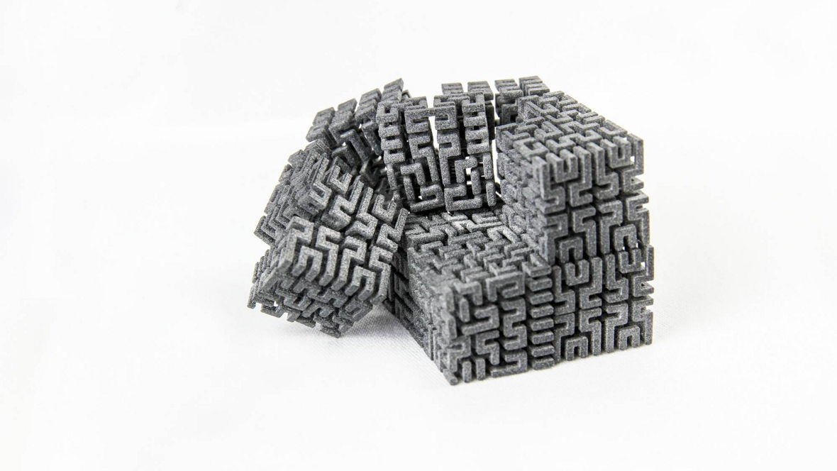 Detailed 3D-printed part with labyrinth-like geometric pattern, manufactured from INFINAM® PA12 nylon powder using High Speed Sintering (HSS).
