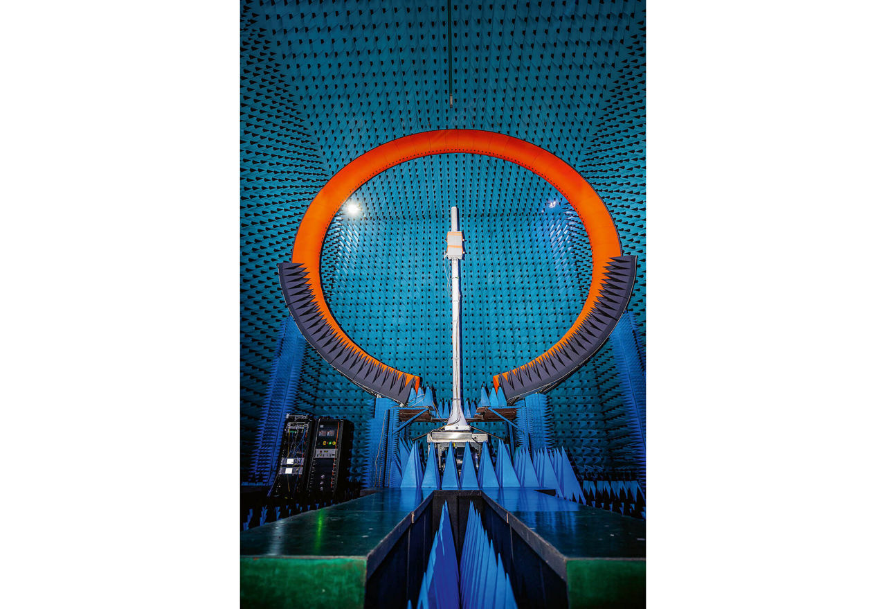 Eine kreisrunde orangefarbene Antenne in einem mit blauen Spitzen ausgelegten Raum.