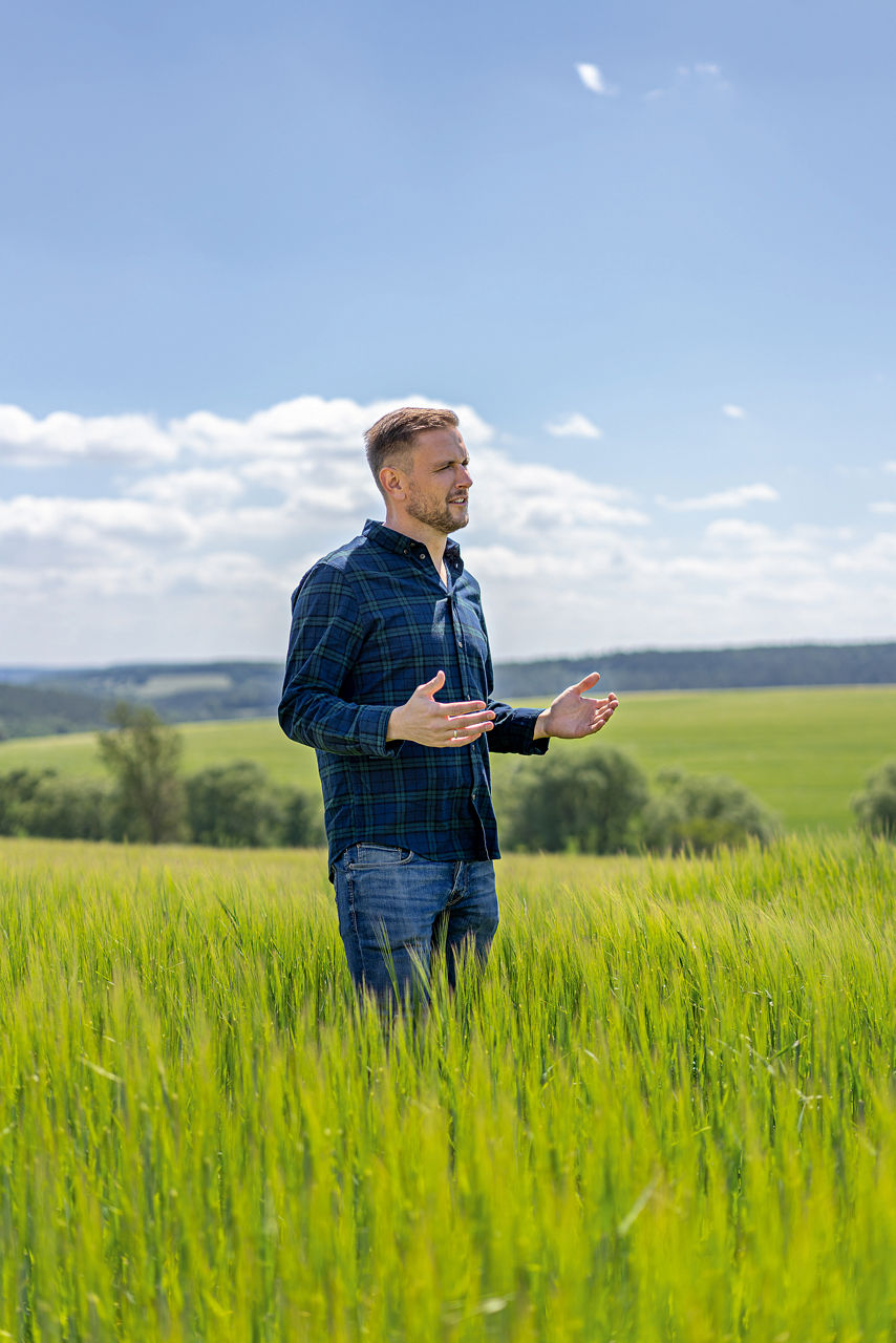 Andreas Dörr steht auf eiem grünen Feld.