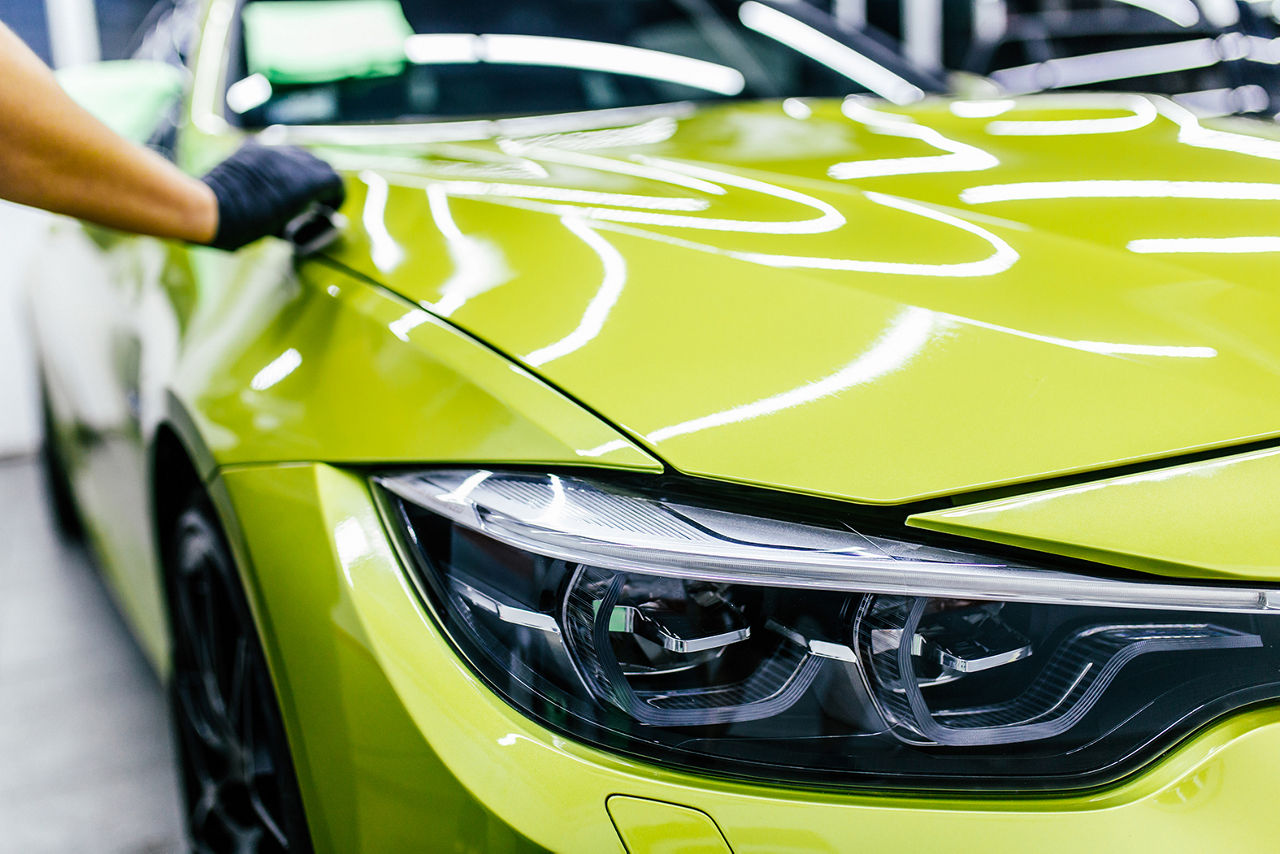 A man cleaning car, car detailing (or valeting) concept. Selective focus. 