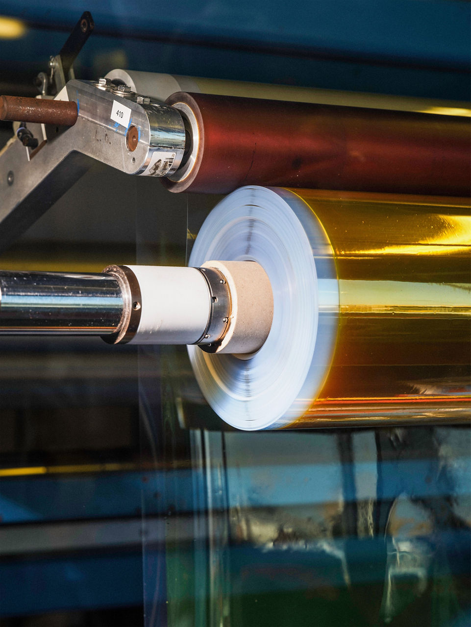 Die fertige Membran wird aufgewickelt. Die Rolle schimmert in goldener Farbe.