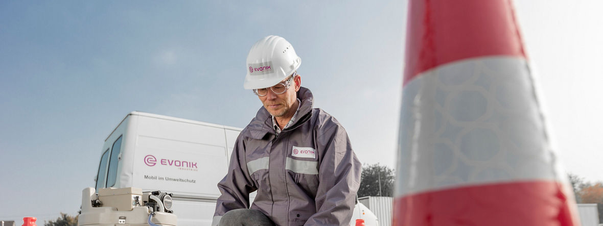 An Evonik employee takes a water sample from a wastewater shaft.