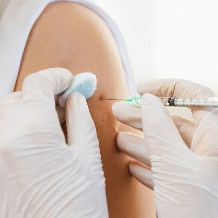 People getting a vaccination to prevent pandemic concept. Mature Woman in medical face mask  receiving a dose of immunization coronavirus vaccine from a nurse at the medical center hospital


Vaccination