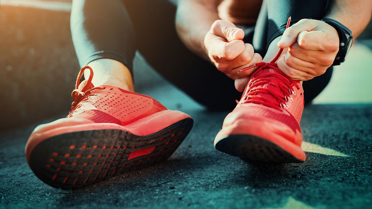 Person tying red athletic shoes—representing Evonik’s PU additives for high-performance, stylish, and durable microcellular foam footwear.