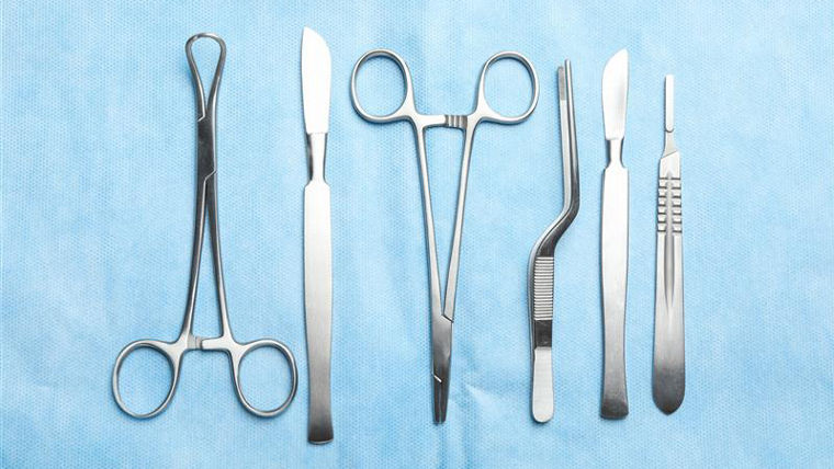 Stainless steel surgical instruments arranged on a sterile surface, representing medical devices with durable, high-performance coating requirements.