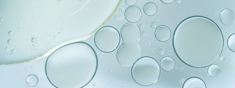 Abstract close-up of translucent bubbles in a clear liquid, symbolizing the diverse chemical components in Evonik’s polyurethane additive brands.