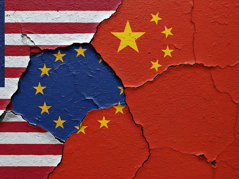 Die Fahnen der USA, der EU und Chinas an eine Wandgemalt, die farben bröckeln leicht ab.