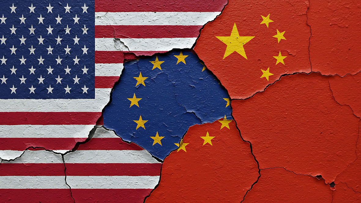 Die Fahnen der USA, der EU und Chinas an eine Wandgemalt, die farben bröckeln leicht ab.