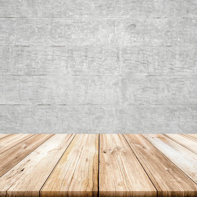 Empty light wood table top with concrete wall background. 