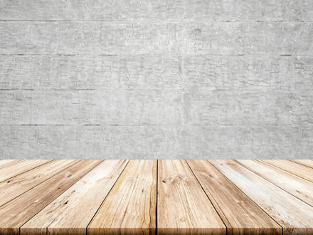 Empty light wood table top with concrete wall background. 