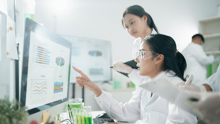 Scientists analyzing data results on laboratory computer monitors, focusing on research, innovation, experiment, teamwork, and biotechnology in modern lab environments for scientific development