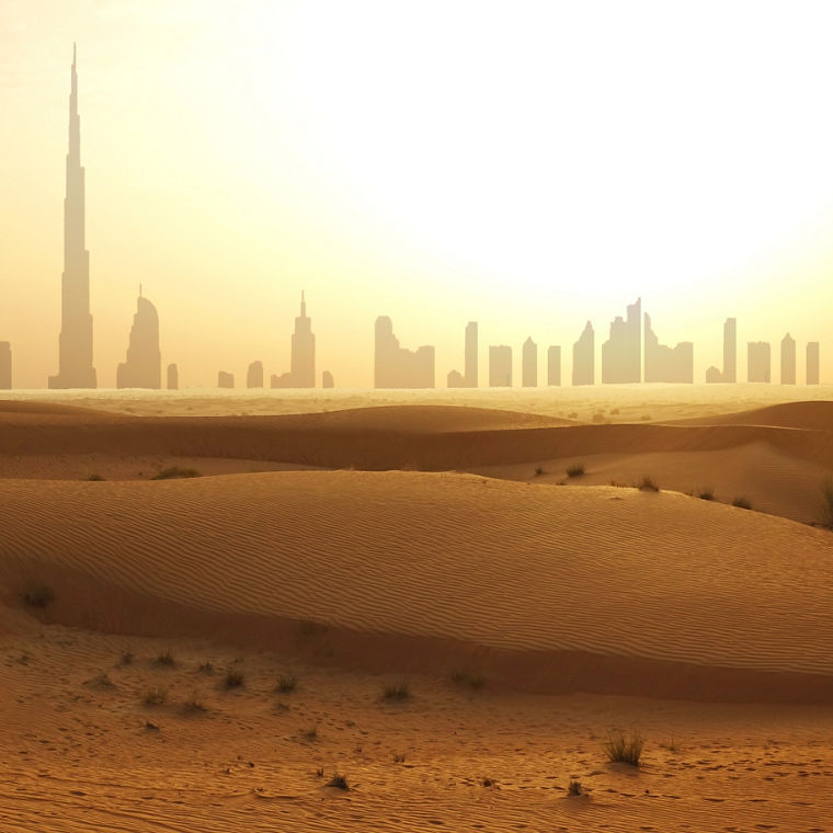 In the foreground dunes, in the background the skyscrapers of Dubai as silhouettes