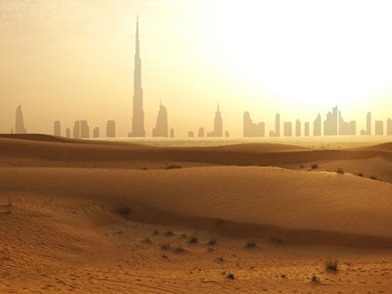 In the foreground dunes, in the background the skyscrapers of Dubai as silhouettes