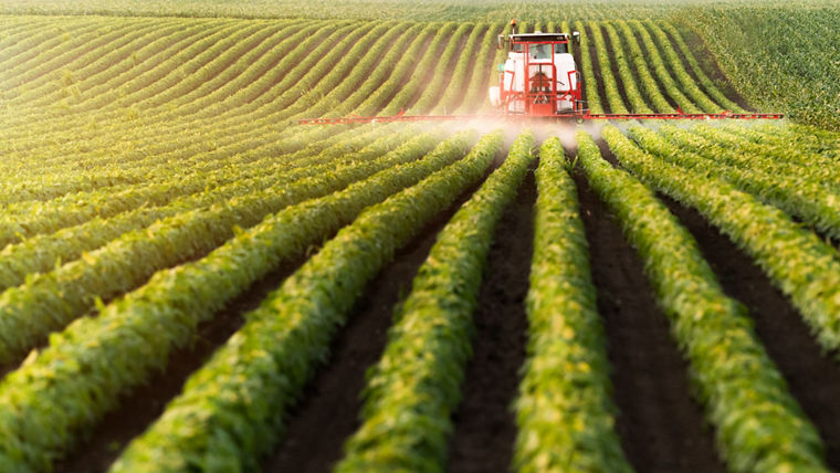 Traktor beim Sprühen von Pflanzenschutzmitteln auf einem Sojabohnenfeld