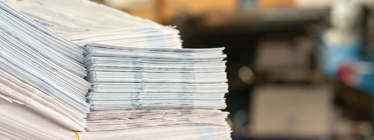 stack of paper bags on table in print shop.