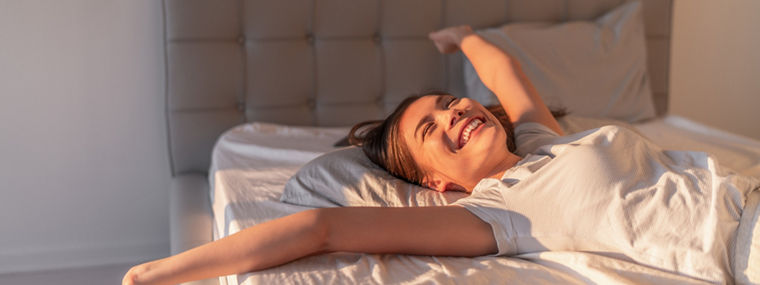 Person on a bed with tufted headboard—representing Evonik’s PU additives for high-quality, sustainable slabstock foam in comfort applications.