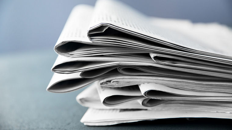 Pile of newspapers on gray background 
