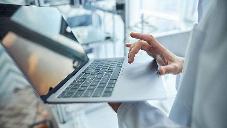 Cropped photo of an engineer sending a 3D model file from his laptop to the printer