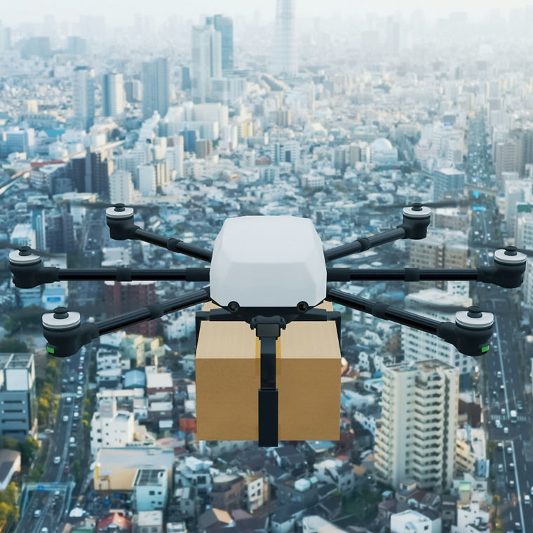 Eine Transportdrohne fliegt über eine Großstadt.